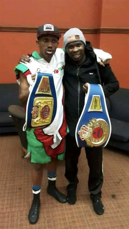 Newly crowned WBF Intercontinental Champ Thato Bonokoane with trainer Charity Mukondeleli who is holding his boxer"s first title the WBF Africa belt.