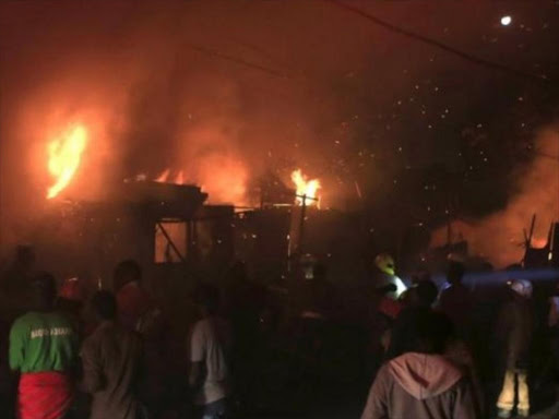 Kibera slum residents try to put out a fire after gas cylinder explosions late into the night in Nairobi, February 29, 2016. /REUTERS