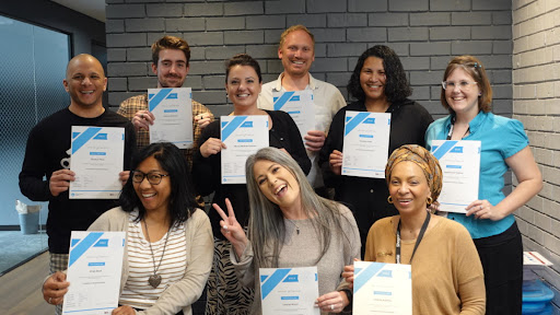 Trainee business analysts showing off their certificates after taking first step on business analysis career path.