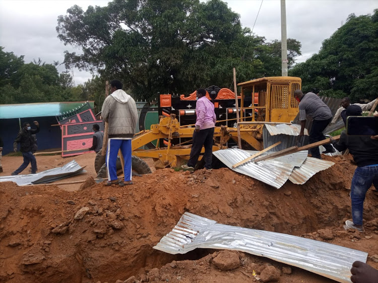 Youth supporting Kitui County assembly speaker George Ndotto on Monday tear down a perimeter fence erected around the disputed plot.