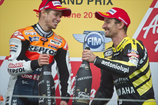 Casey Stoner (L) of Australia and Repsol Honda Team and Colin Edwards of USA and Monster Yamaha Tech 3 celebrate on the podium at the end of the MotoGP race of MotoGp Of Great Britain at Silverstone Circuit on June 12, 2011 in Northampton, England