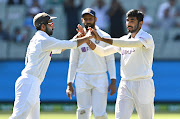 Jusprit Bumrah celebrates with teammates after taking a wicket. 