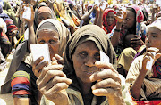 Displaced women wait to receive non-food items from the UN High Commissioner for Refugees at the Maajo settlement. File photo.