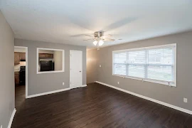 Living room with wood-inspired flooring with view of the kitchen