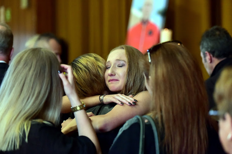 Mark Minnie's daughter, Brooklyn, is comforted at her dad's memorial service in Port Elizabeth on August 24.