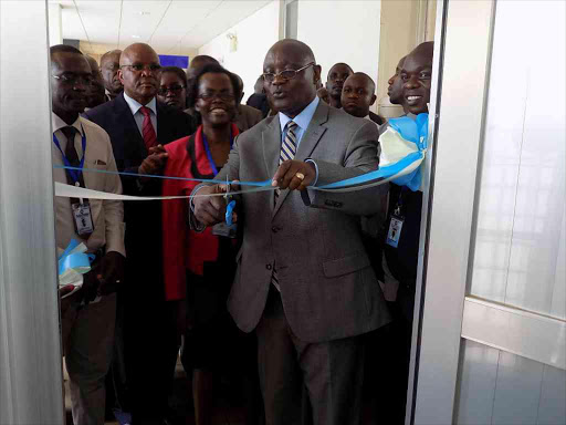 Kisii Governor James Ongwae cuts a ribbon during the opening of icu and HDU Units at Kisii Teaching and Referral Hospital on Tuesday. Photo Benson Nyagesiba