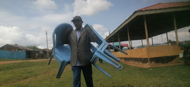 A man clears chairs off the venue where a public hearing on a bill rooting for Kisii Deputy Governor Robert Monda impeachment was being held in Gesusu market, Nyaribari Masaba (IMAGE BY MAGATI OBEBO