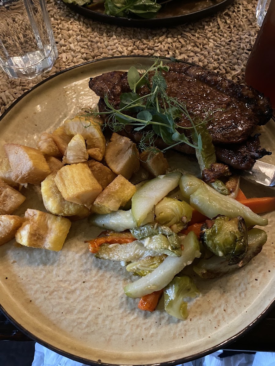 Very tender well seasoned steak with veggies and fried yucca