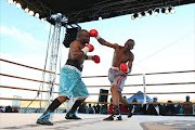 Nkululeko Mhlongo from Soweto cracks East London former champ Sikhulule Sidzumo (bue trunks) during their SA Junior Middleweight title bout at Bhisho Stadium on Saturday Picture: MARK ANDREWS
