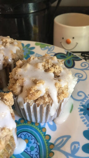 Pumpkin Crumb Cake muffin drizzled with icing on a decorative plate