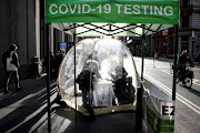 People take coronavirus disease (Covid-19) tests at a pop-up sidewalk testing site in New York, US, December 1, 2021. 