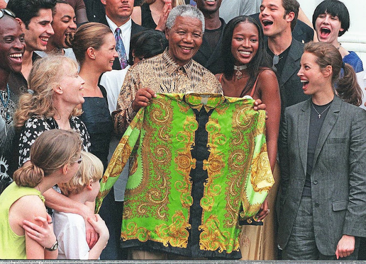 Fashion icon: Nelson Mandela with one of his famous shirts, surrounded by supermodels. Picture: Getty Images/AFP/Anna Zieminski