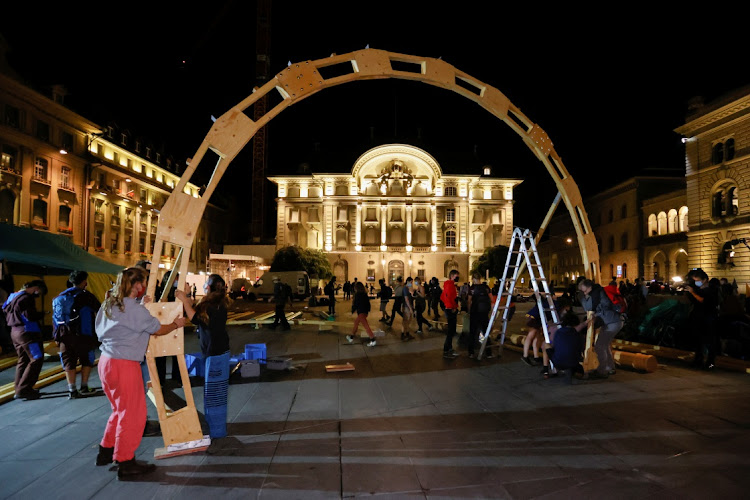 Climate change activists build a structure during a demonstration called 'Rise up for change' in front of the Swiss National Bank, in Bern, Switzerland, on Monday.