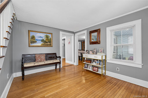 Living room with bench and painting in this luxury property for sale in Bayville ($765,000)