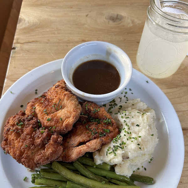 Fried chicken dinner with gravy, mash potatoes, and green beans