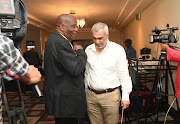 Maritzburg United owner-chairman  Farook Kadodia (R) chats to his Black Leopards counterpart David Thidiela (L) after the Premier Soccer League board of governors meeting in Johannesburg on March 18 2020.