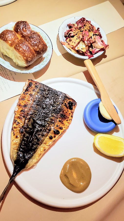 A Dinner at Erizo, chicories and anchovy vinaigrette, and bbq chub mackerel with homemade take on parker house rolls