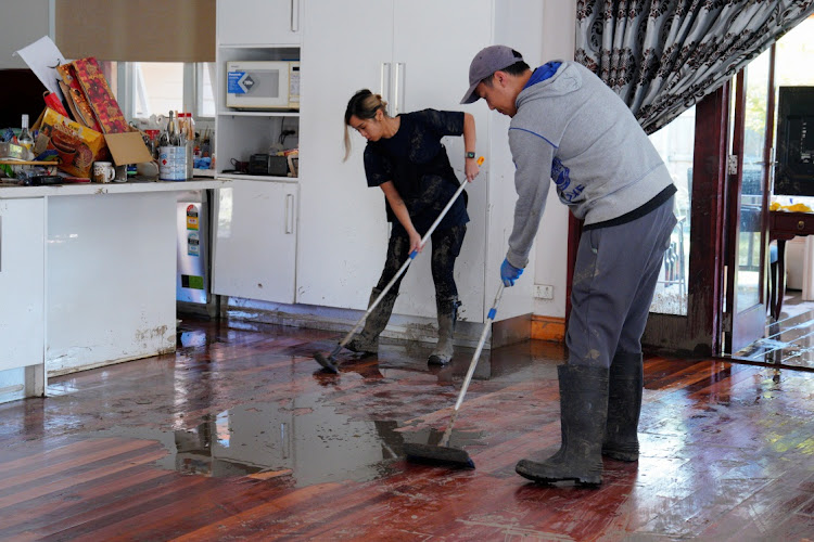 Mimi Tran and Tim Tran assist a family member with cleanup efforts inside a damaged home following severe flooding in the Maribyrnong suburb of Melbourne, Australia, on October 17 2022. Picture: REUTERS/SANDRA SANDERS