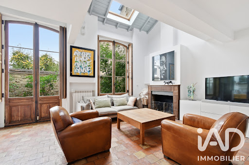 Living room with leather armchairs and large bay window in this luxury house for sale in Marly-le-Roi ($1,000,472 - 177 m²)