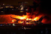 Firefighters work at Haneda International Airport after Japan Airlines' A350 airplane caught on fire in Tokyo, Japan, on January 2 2024.