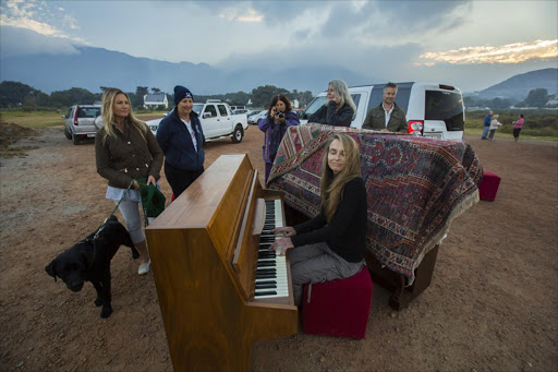 Noordhoek resident Ann Middleton plays her piano at sunrise after she and other homeowners were evacuated from their properties as fires raged in the Cape Peninsula this week.