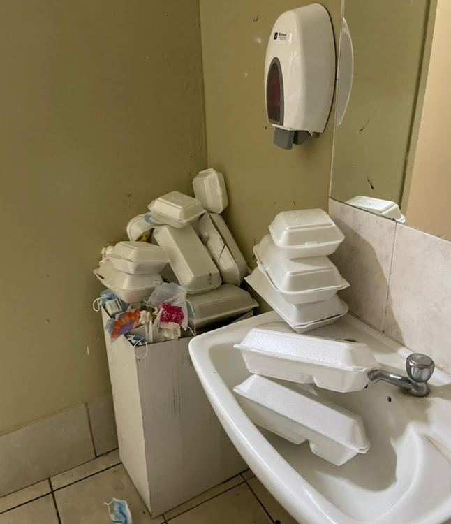 Discarded food containers piled up in a bathroom used by script markers.