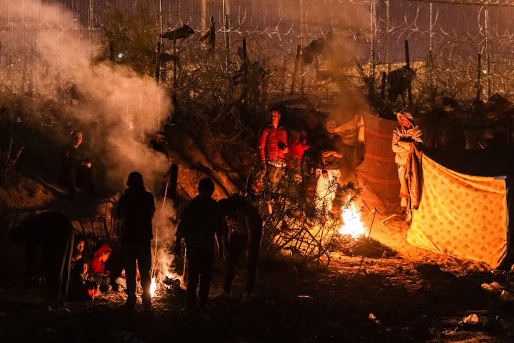 A group of migrants camp out along the border wall on the U.S. side of the Rio Grande after the U.S. Supreme Court let a Republican-backed Texas law known as SB 4 take effect, allowing state law enforcement authorities to arrest people suspected of crossing the U.S.-Mexico border illegally, in El Paso, Texas, U.S., as seen from Ciudad Juarez, Mexico March 19, 2024.