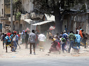 Civilians run from the scene of an explosion after al-Shabaab militia stormed a government building in Mogadishu, Somalia on March 23, 2019. There was no immediate claim of responsibility for Saturday's attack, but al-Shabaab, which wants to overthrow the government and impose its strict interpretation of Islamic sharia law, frequently carries out such bombings.

