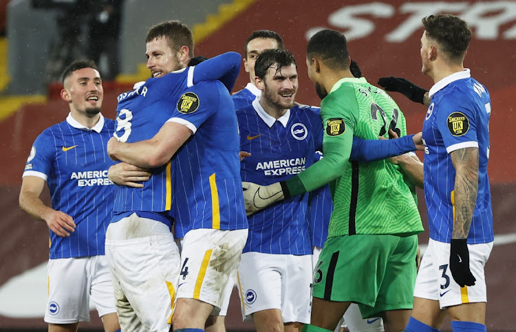 Brighton & Hove Albion’s Adam Webster celebrates with Yves Bissouma, Pascal Gross, Robert Sanchez and teammates after the visitors defeated high-flyers Liverpool at Anfield, in Liverpool, on Wednesday night