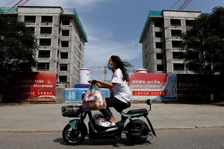 A person rides past a construction site of residential buildings by Chinese developer Country Garden in Tianjin, China, on August 18 2023. Picture: TINGSHU WANG/REUTERS