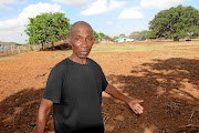 Paulus Swele, 64, points to where his children were  buried, with    grave markings  allegedly destroyed by the farmer. 