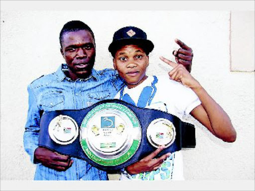 National bantamweight champion Bukiwe Nonina, left, and her trainer Emmanuel Neluoende show off her belt.