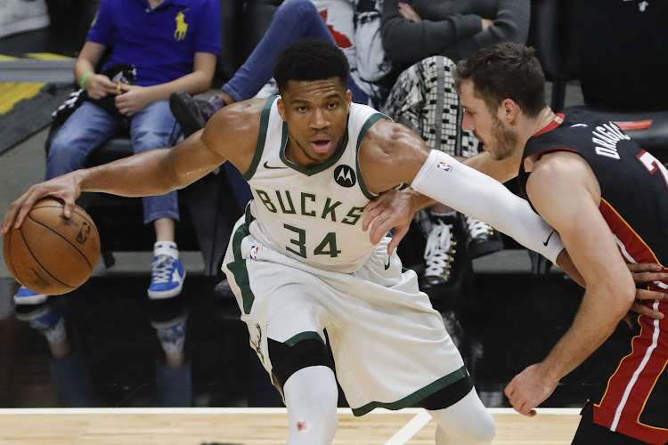 Milwaukee Bucks forward Giannis Antetokounmpo dribbles the basketball under challenge from Miami Heat guard Goran Dragic