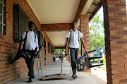 Rephafogile secondary school pupils in Mamelodi, east of Pretoria, carry their desk and chairs with as they change classes. Vandalism and theft have negatively affected the school. 