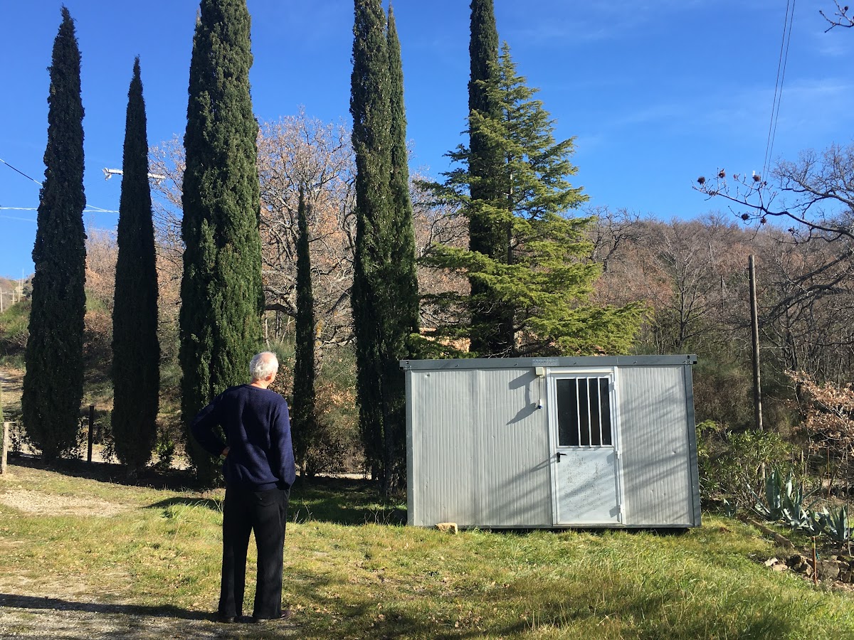 Back portrait, wondering about the yard cabin in the garden, nestled amongst the cipreses and the lush greenery of Podere Santa Pia