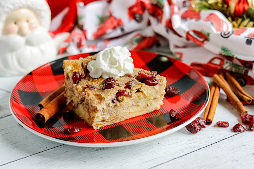 A slice of Cranberry Eggnog Bread Pudding on a plate.