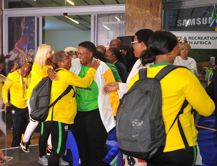 Sports Minister Tokozile Xasa hugs Banyana Banyana head coach Desiree Ellis during the senior women's national team's arrival from the African Women's Cup of Nations in Ghana at OR Tambo International Airport in Johannesburg.