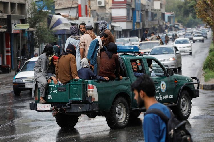 Taliban fighters drive a car on a street following the killing of Al Qaeda leader Ayman al-Zawahiri in a U.S. strike over the weekend, in Kabul, Afghanistan.