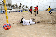 Stephano Walles Mapunda of Tanzania beats Mozambican goalkeeper Manuel Domingos Tivane in their clash during the COSAFA Beach Soccer Tournament in Durban.   