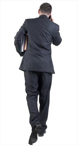 back view of walking business man with books. - Stock image