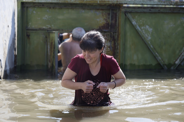 A woman walks near a flooded house following the destruction of the Kakhovka dam, in Kherson, Ukraine, June 7 2023. Picture: ALEX BABENKO/GETTY IMAGES