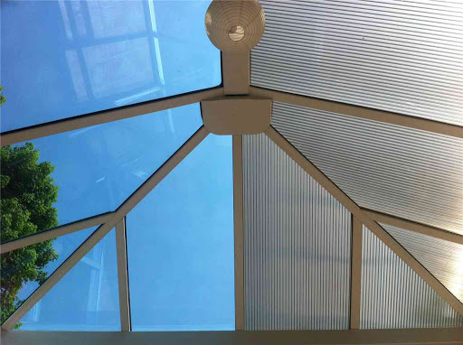 In this picture we are half way through replacing the customers original polly carb roof panels for self cleaning active blue glass.