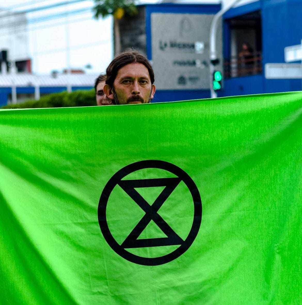 Cesar stands holding a giant green XR Banner so only his head is visible