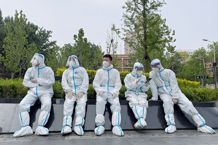 Workers in protective suits rest near a makeshift nucleic acid testing site amid the Covid-19 outbreak in Beijing, China, on April 29 2022. REUTERS/ALESSANDRO DIVIGGIANO