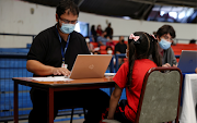 A child prepares to receive a dose of Sinovac's CoronaVac Covid-19 vaccine as the Chilean sanitary authority continue the vaccination campaign against the coronavirus disease for 6 to 11-year-olds, in Santiago, Chile on October 29, 2021. 
