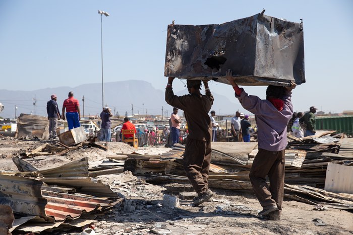 Residents carry out their burnt belongings