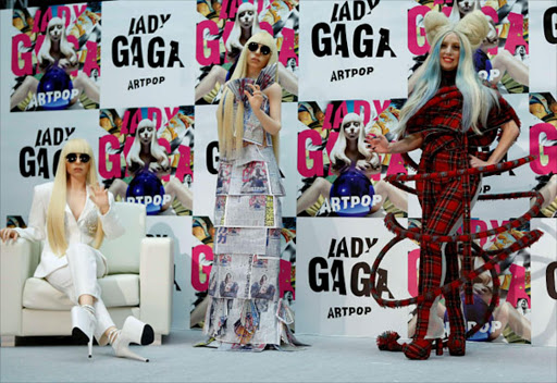 Singer Lady Gaga (R) poses with Gagadolls during a news conference to promote her latest album "Artpop" in Tokyo. REUTERS