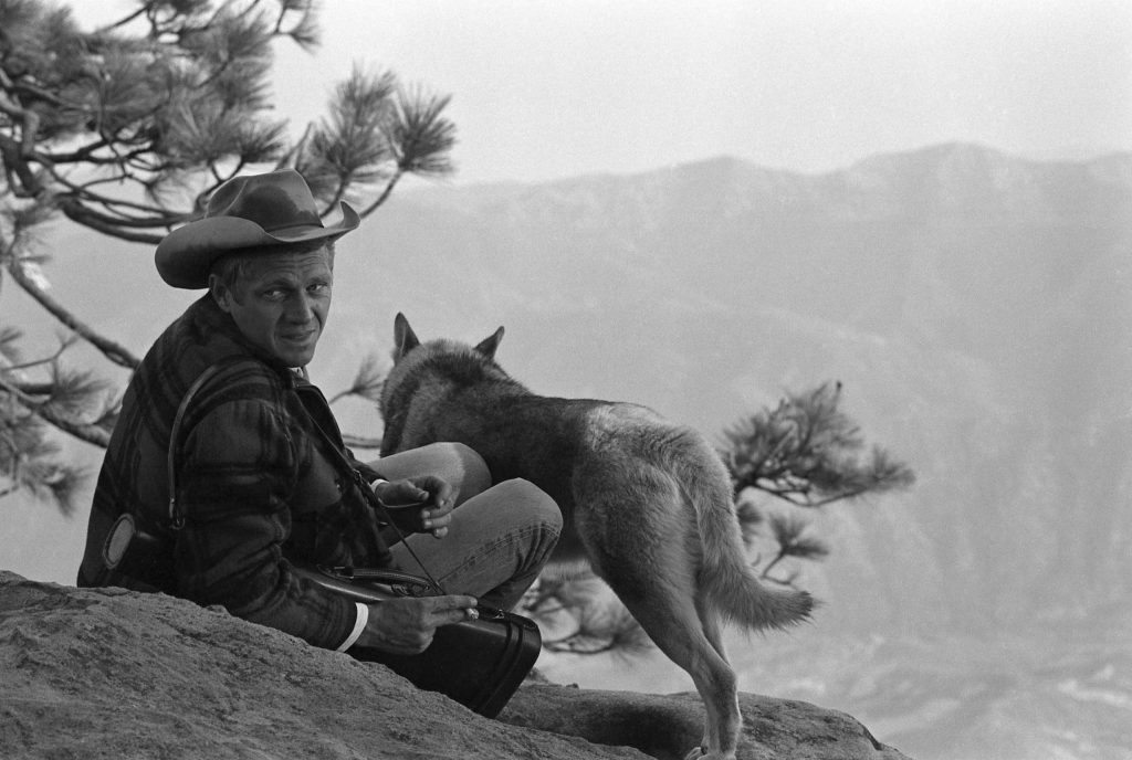 With his dog, a Malamute named Mike, by his side, Steve McQueen takes in the scenery, California, 1963.