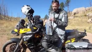 Motorcyclist taking a hydration break with a plastic drinking bag  on a dirt trail