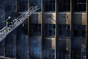 A firefighter works at the scene of a deadly fire in Johannesburg CBD on August 31 2023. 